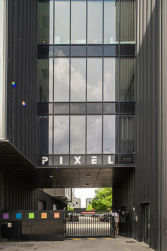 Façade vitrée avec passage souterrain dans la zone industrielle Pôle PIXEL en France.