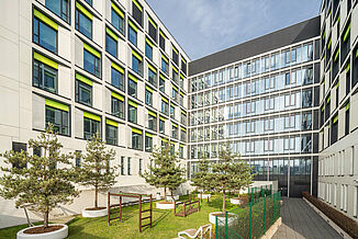 Bâtiment de l'hôpital pédiatrique de la clinique universitaire de Varsovie avec espace vert et aire de jeux.