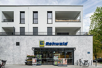 Supermarché Edeka dans un nouveau bâtiment à Munich avec des appartements au-dessus.