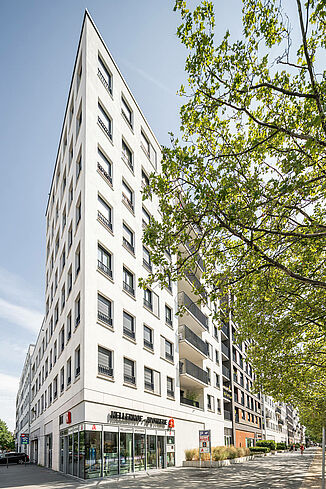 Vue d'angle du quartier Alea à Francfort avec la pharmacie et les appartements situés au-dessus.