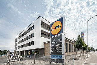 Bâtiment à usage mixte comprenant un Lidl, des appartements et une aire de jeux.