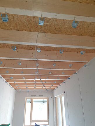 Plafond suspendu à poutres en bois avec REGUFOAM hangers dans une maison de retraite à Kümmersbruck.