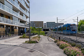 train passant devant un ensemble d'immeubles dotés de balcons